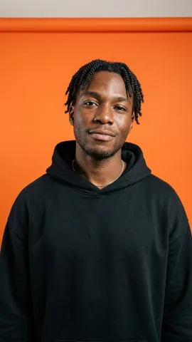 The photo of the man in front of an orange backdrop