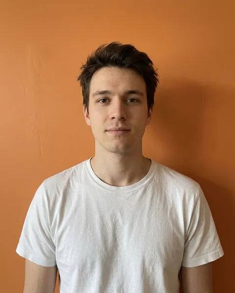 Man facing the camera in front of an orange wall